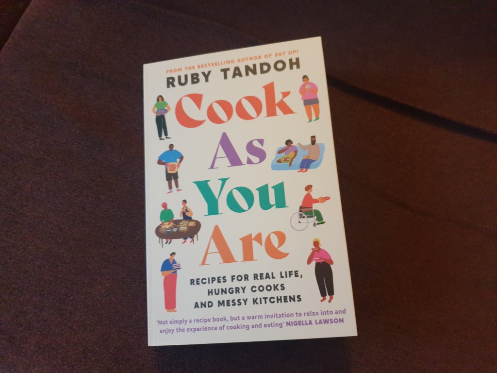 A copy of Ruby Tandoh's book, Cook As You Are' lying on a brown background. 