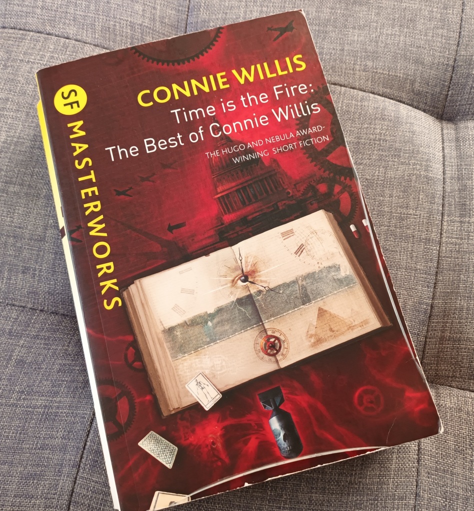 A copy of the the collection, Time is the Fire: The Best of Connie Willis', sitting on a grey background. 
